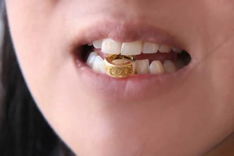 Dùng răng cắn để kiểm tra độ mềm của vàng, một cách phân biệt vàng thật giả truyền thống