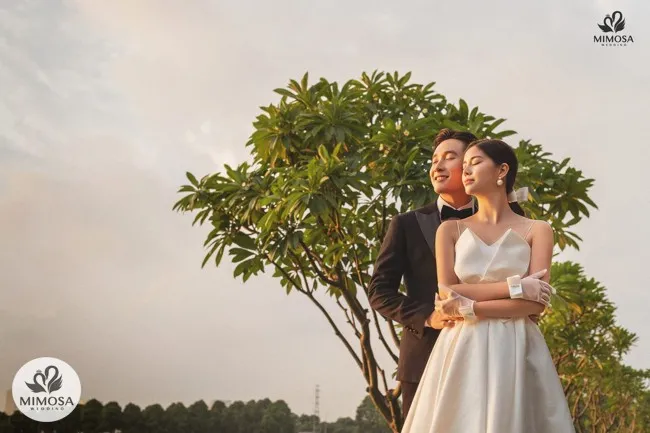 Một cặp đôi đang nắm tay nhau bước đi trong khung cảnh tuyệt đẹp của hoàng hôn