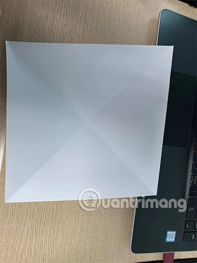 Gấp hai đường chéo trên tờ giấy vuông để tạo nếp