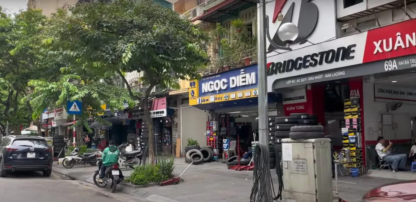 Góc nhìn cận cảnh một con phố nhộn nhịp với nhiều cửa hàng và biển hiệu